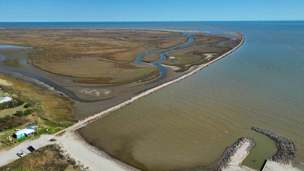 Aerial view from above the North Jetty, marsh on left side for birding and crabbing, and bay water on right side for fishing