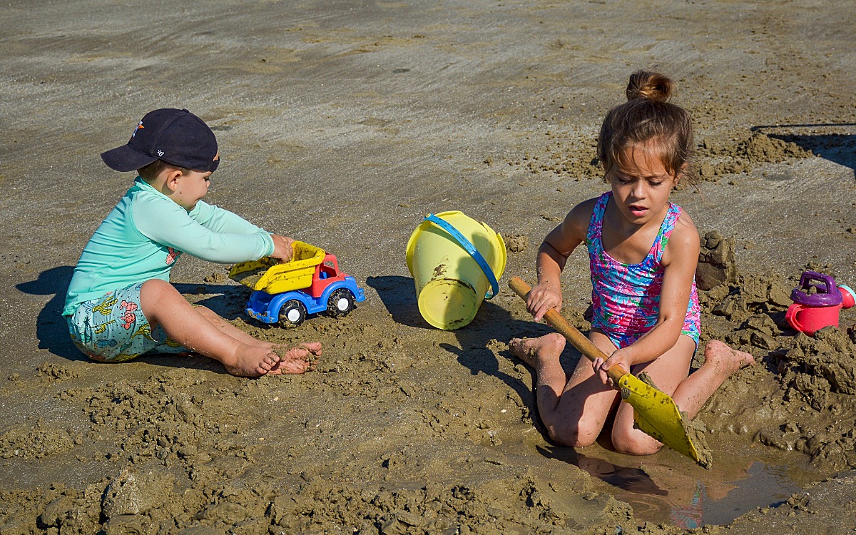 Kids playing in sand on beach