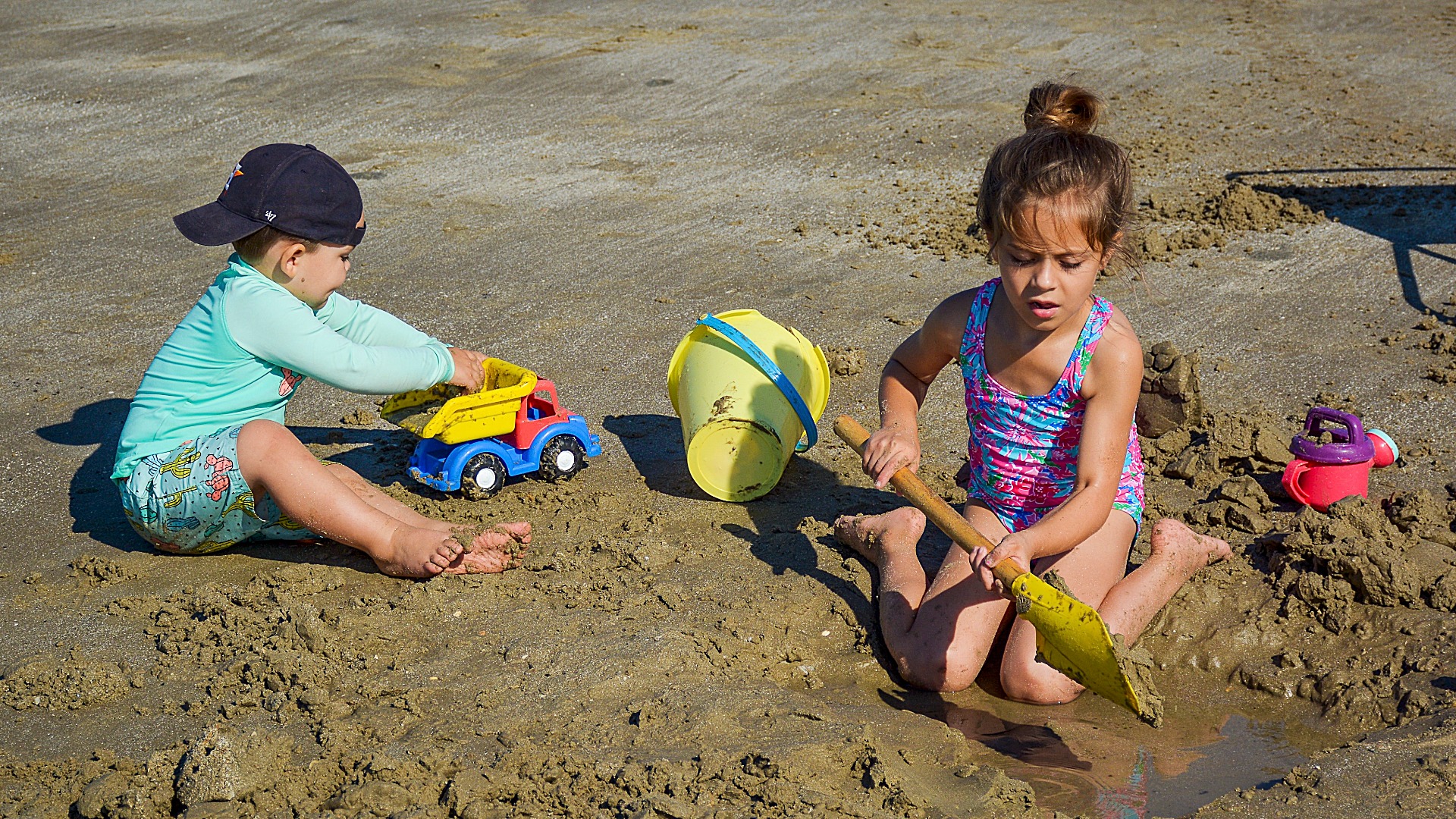 kids on beach building sand castle